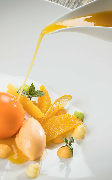 Meal with melon and orange in the toque-awarded restaurant in your sports hotel in Kitzbühel